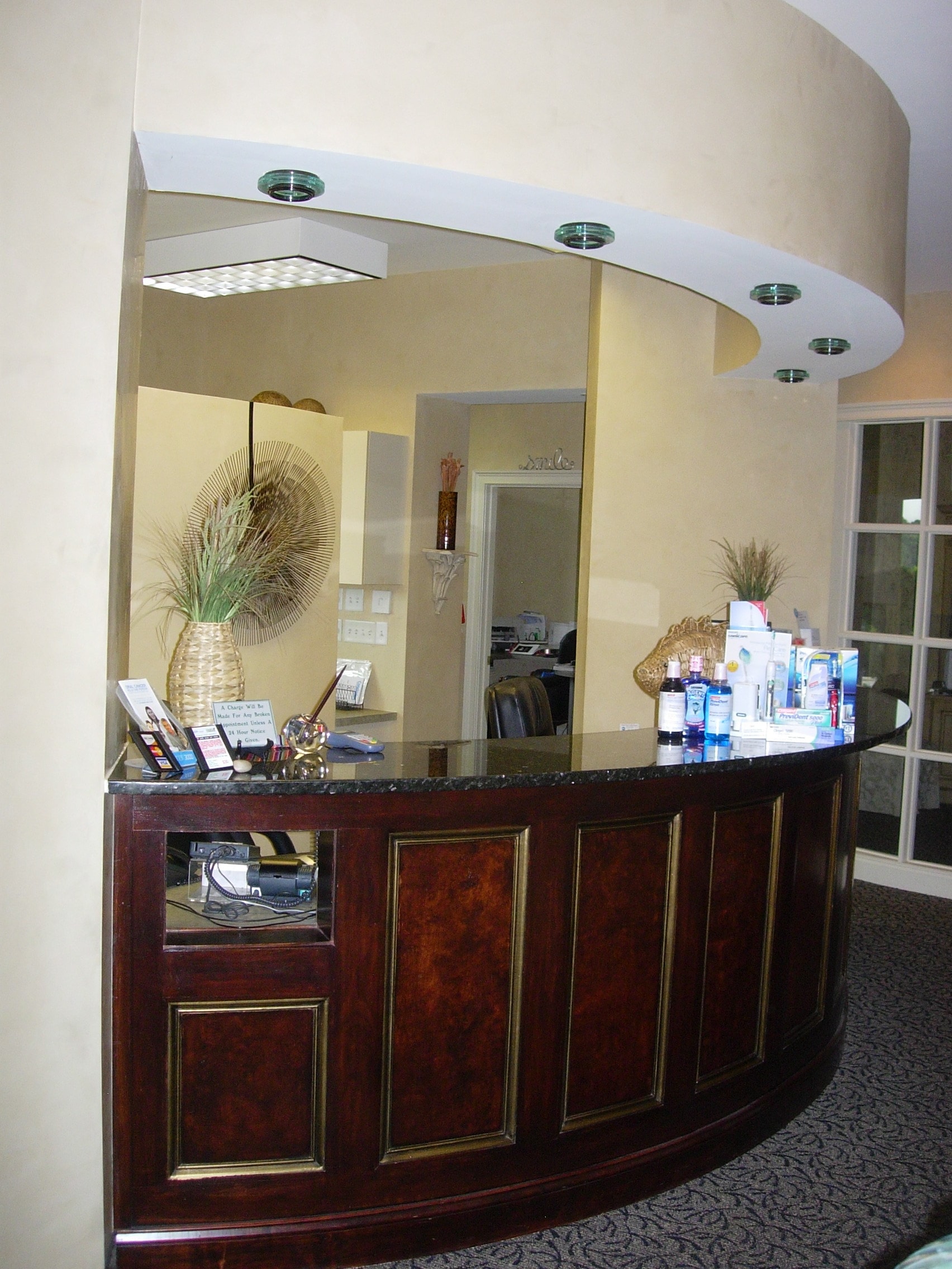 Elegant curved reception desk with warm lighting at Thomas H. Pitts DMD